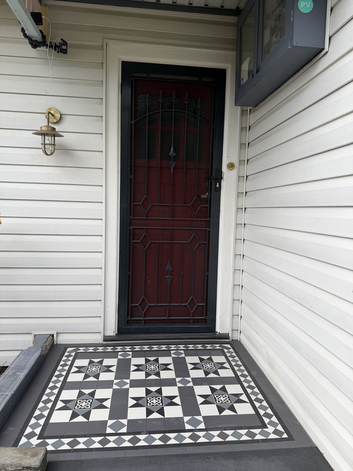 Close view of an encaustic landing panel and Norwood diamond border at a front door, Ashbury