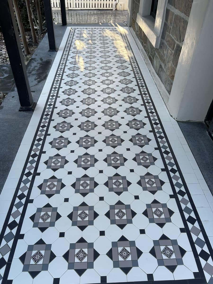 Black, white, light grey and green Glasgow verandah with a Norwood border on a bluestone cottage, Unley